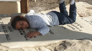 מרגש: הילד נשכב על קבר אביו