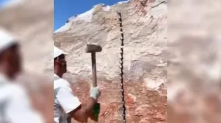 תיעוד מדהים: אדם שובר סלע עצום בידיים