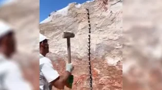 תיעוד מדהים: אדם שובר סלע עצום בידיים