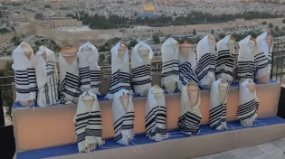 מול מקום המקדש: ספרי תורה עתיקים הובאו לטקס גניזה בהר הזיתים