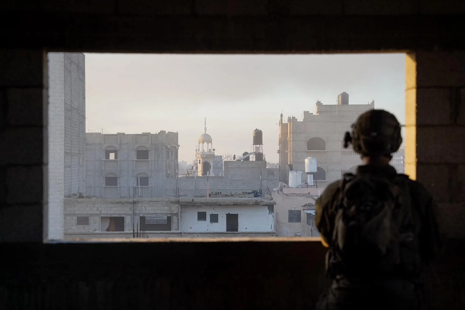 לוחם משקיף מחלון על מבנים בעזה לוחם משקיף מחלון על מבנים בעזה