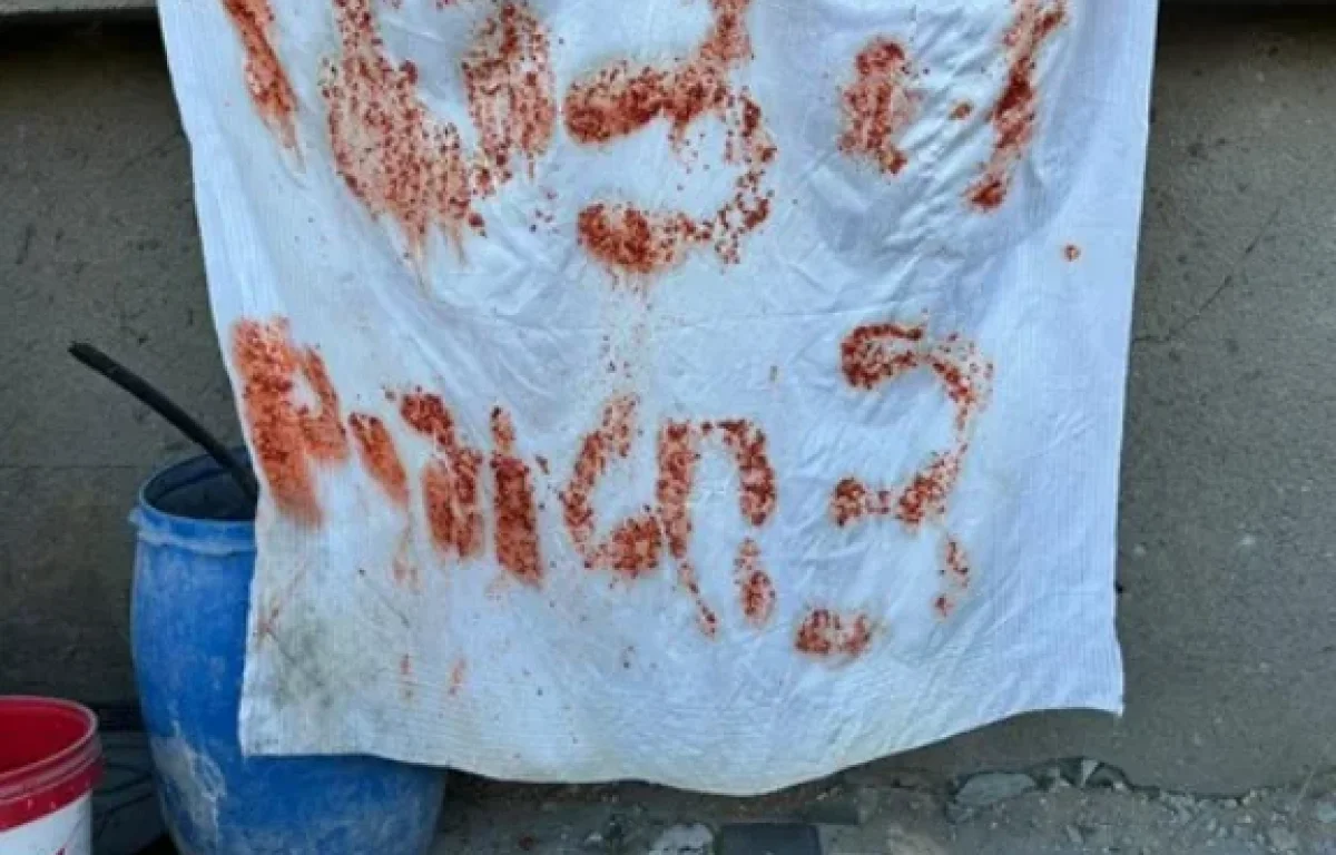 שלט שהכינו החטופים במסע הבריחה משאריות אוכל