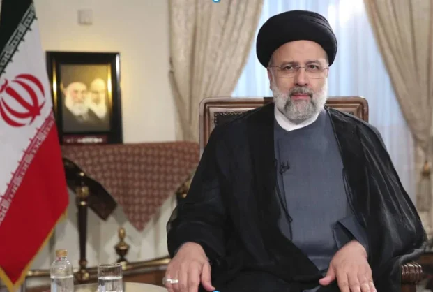 אבראהים ראיסי, וברקע תמונותיהם של המנהיגים העליונים של איראן.