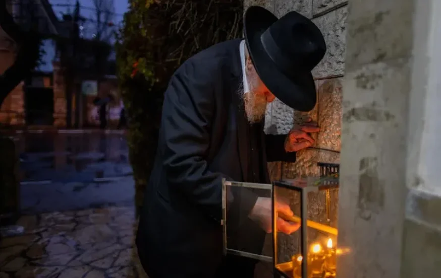 יהודי בירושלים מדליק את נרות החנוכה יהודי בירושלים מדליק את נרות החנוכה