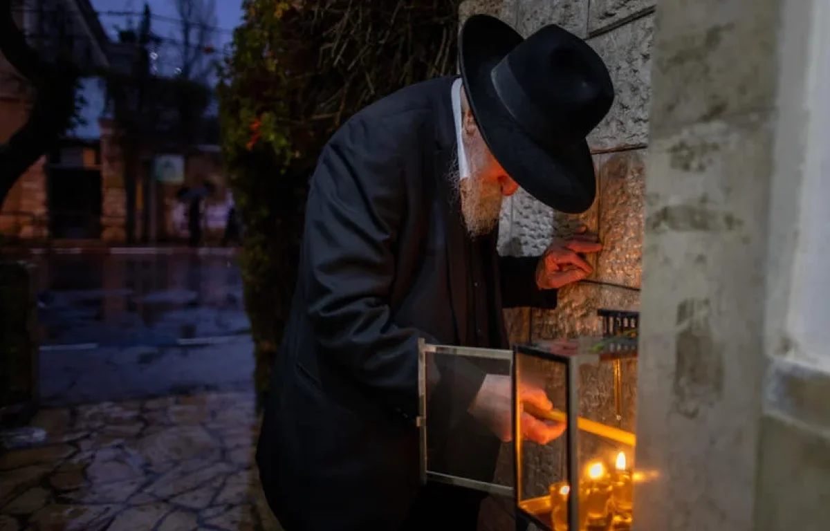 יהודי בירושלים מדליק את נרות החנוכה