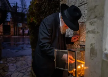 יהודי בירושלים מדליק את נרות החנוכה