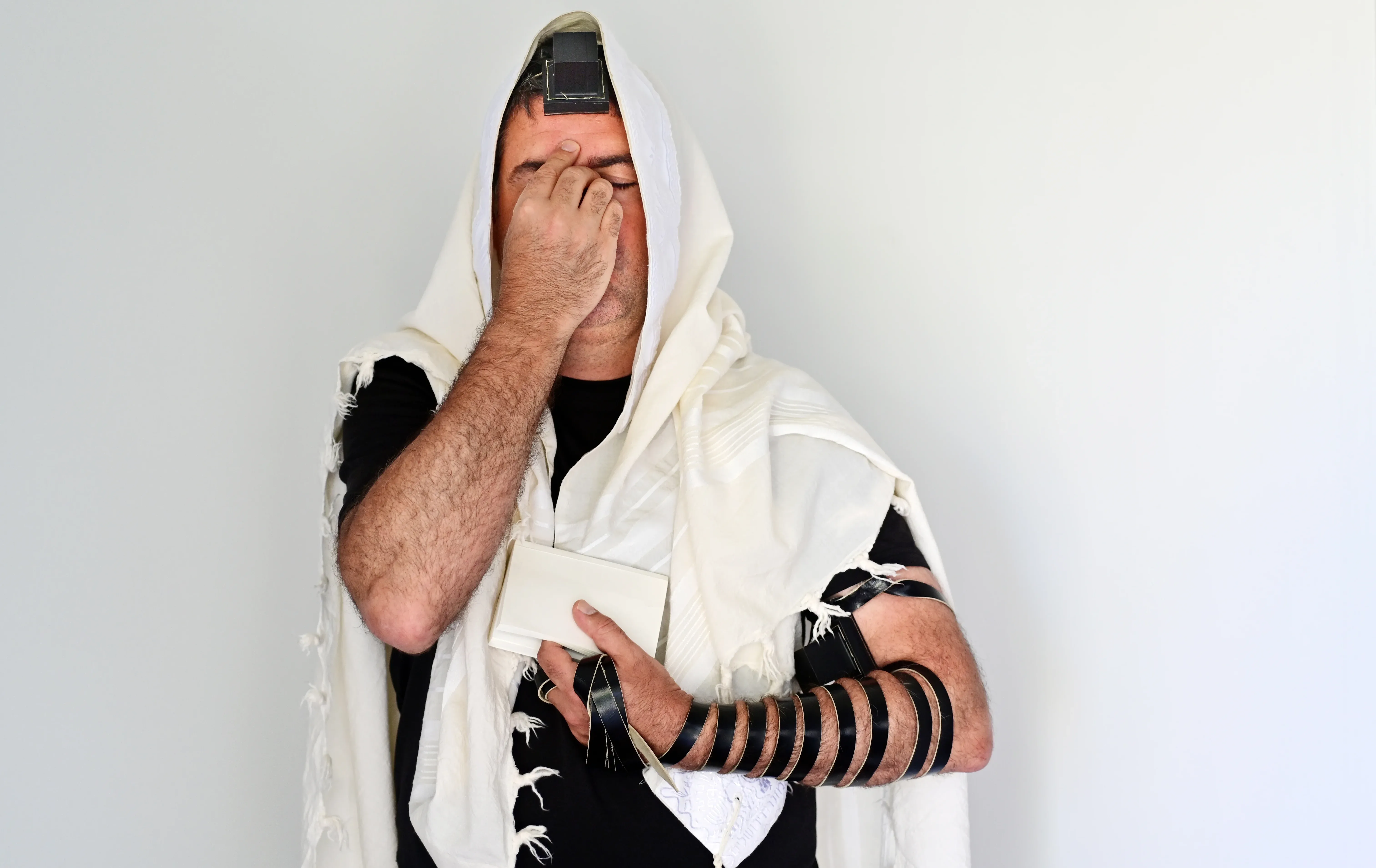 גבר יהודי מניח תפילין בתפילת שחרית