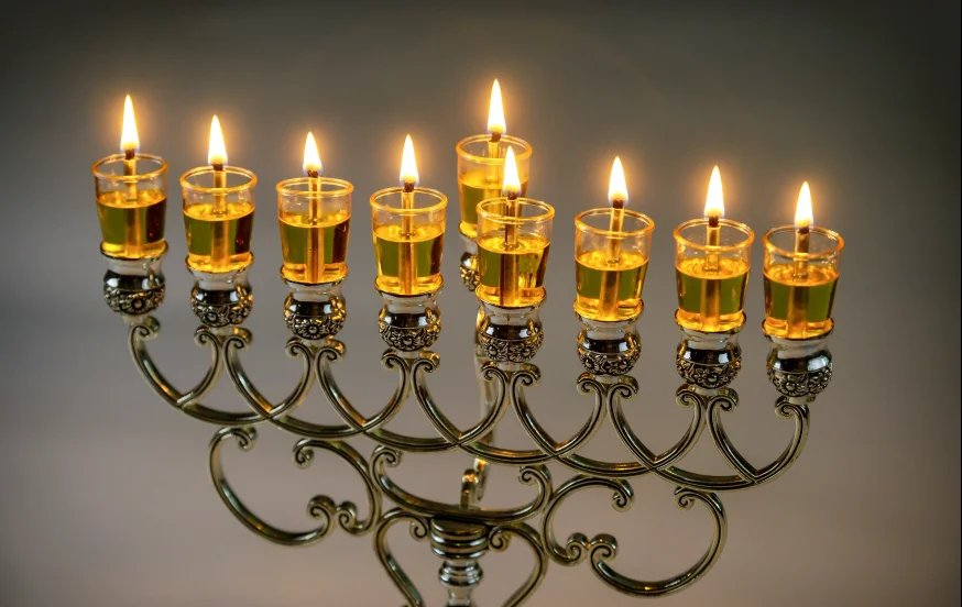 נרות חנוכה דולקים עם אור חם המבטא את סודות החג והפנינים הרוחניות של חנוכה