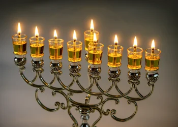 נרות חנוכה דולקים עם אור חם המבטא את סודות החג והפנינים הרוחניות של חנוכה