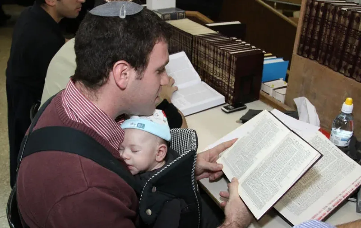 אב לומד תורה עם תינוק ביד אב לומד תורה עם תינוק ביד