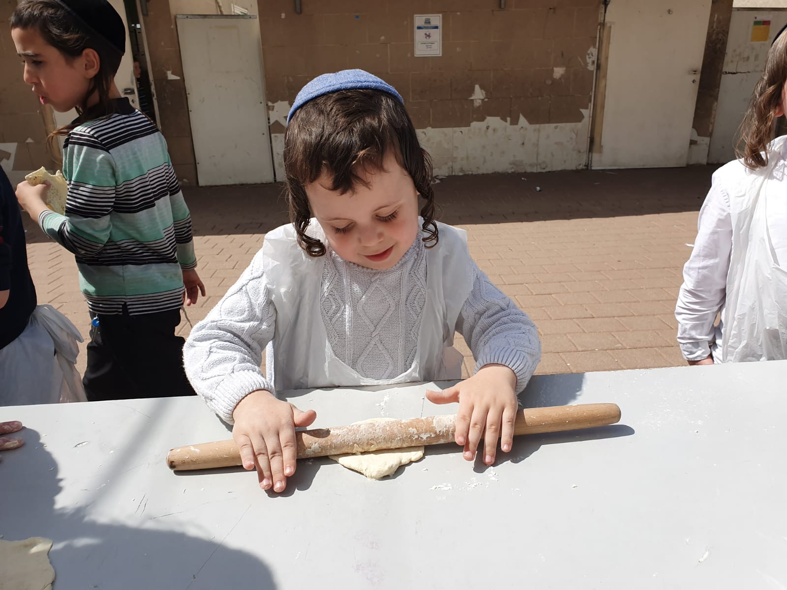 (צילום: באדיבות המצלם) | אחד התלמידים מרדד את הבצק